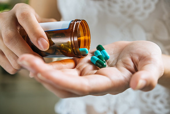 Woman pouring pills into her hand